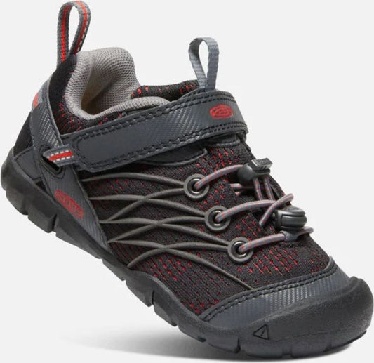 A children's athletic shoe in black and red with gray accents, featuring a bungee cord closure and Velcro strap.