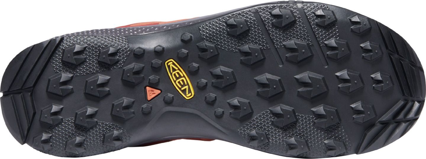 The outsole of a shoe, featuring a dark color, a tread pattern consisting of triangle-shaped lugs, and the brand name KEEN.