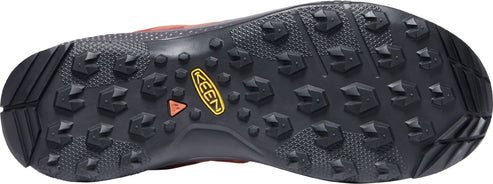 The outsole of a shoe, featuring a dark color, a tread pattern consisting of triangle-shaped lugs, and the brand name KEEN.