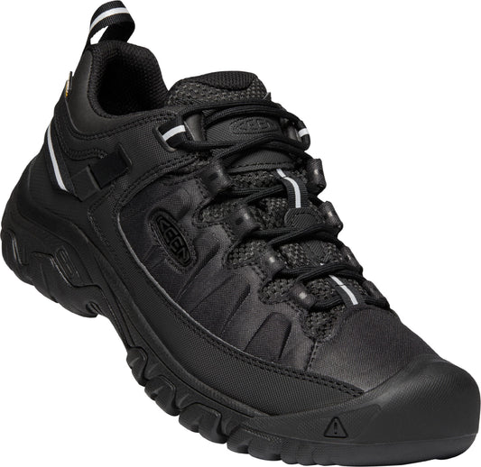 A black low top hiking shoe with a round toe, black laces, and a pull tab.