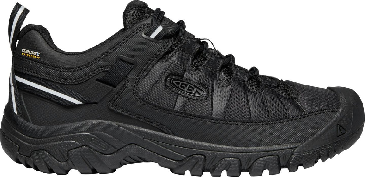 A black hiking shoe with a thick sole and a KEEN logo on the side.