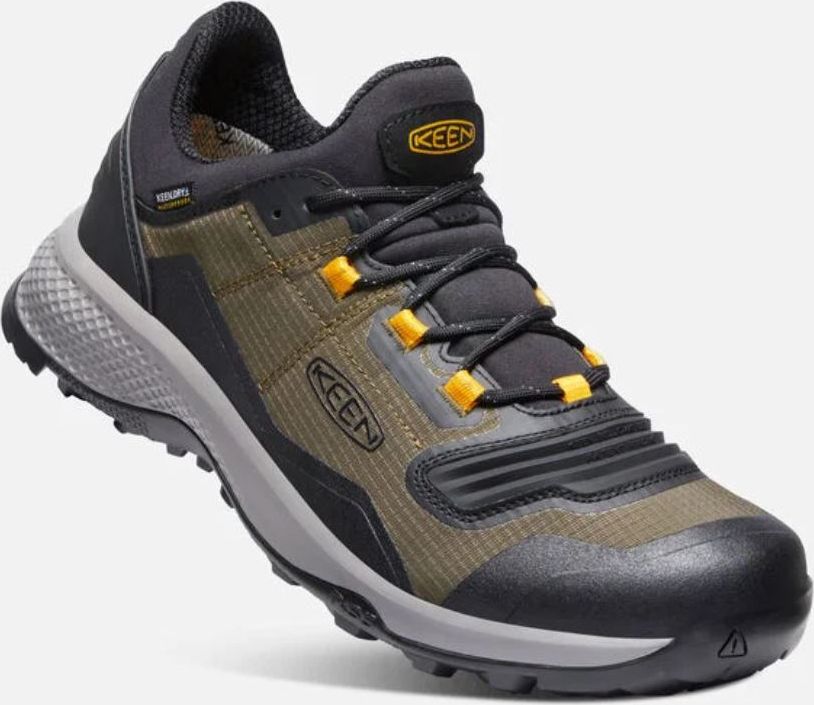 Close-up of a low top hiking shoe in dark gray, olive green, and mustard, with black laces and gray sole.