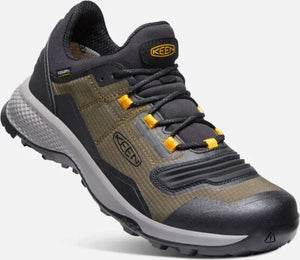 Close-up of a low top hiking shoe in dark gray, olive green, and mustard, with black laces and gray sole.