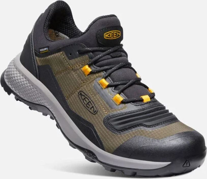 Close-up of a low top hiking shoe in dark gray, olive green, and mustard, with black laces and gray sole.