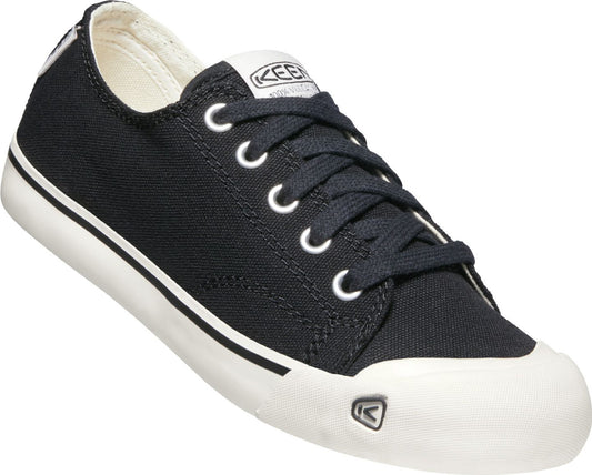 Black canvas sneaker with white rubber toe cap and sole, lace-up closure and logo on tongue.