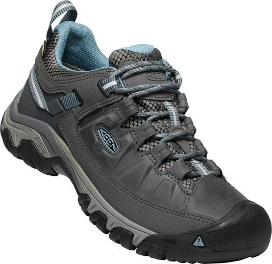 Gray hiking shoe with black toe, rugged sole, and light blue trim.
