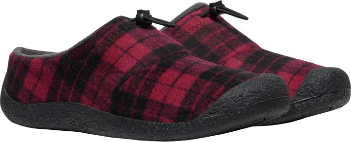 A pair of red and black plaid slippers with black soles.