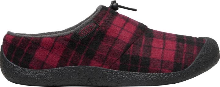 A slip-on shoe with a black and red plaid pattern and a black sole.