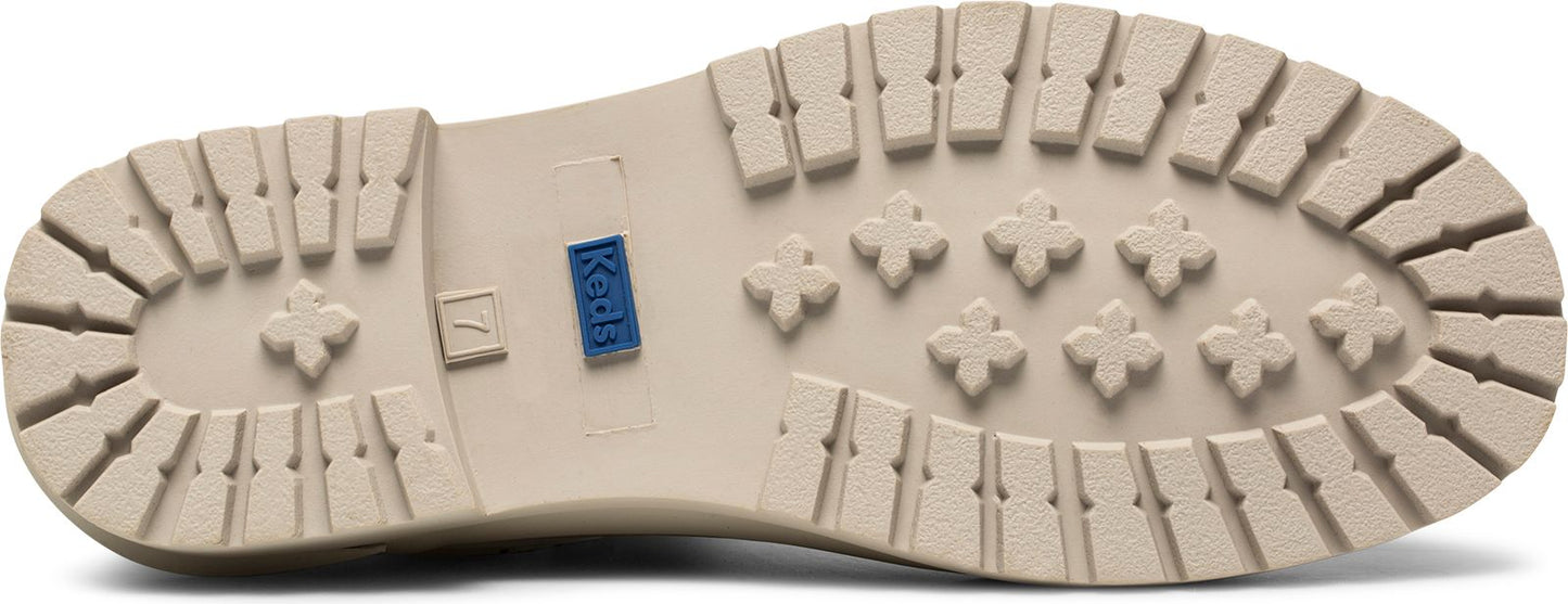 Beige shoe sole with flower shaped treads and a blue tag that says Keds.