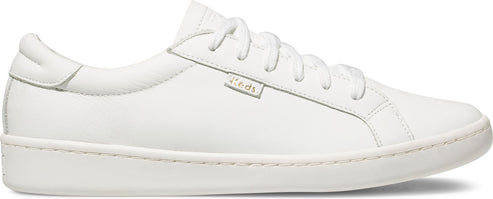 White sneaker with laces and a visible tag with text "Keds" on it.