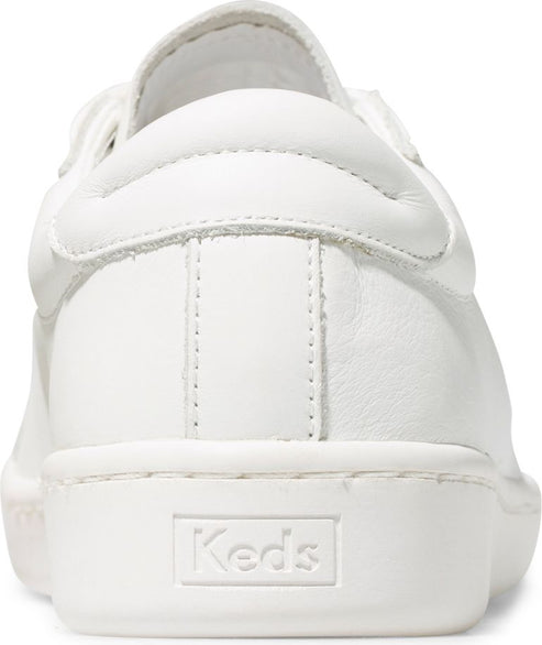 White leather sneaker from the back with the word "Keds" embossed on the heel.