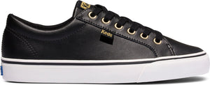 A black low-top sneaker with black laces, gold eyelets, and a white sole.