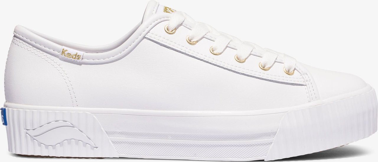 White leather sneaker with gold metal eyelets and visible Keds branding.