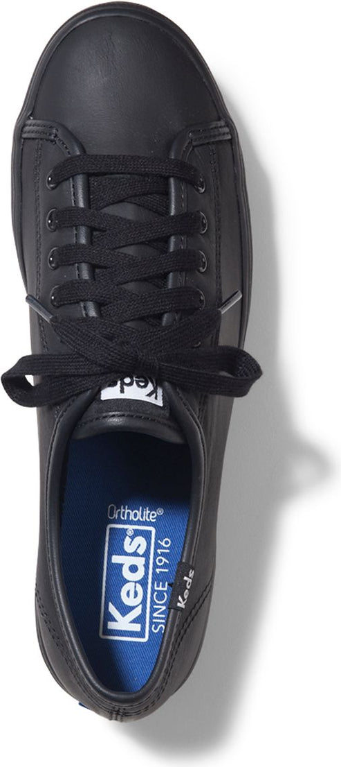 A black sneaker with a blue insole that reads "Keds Since 1916 Ortholite".