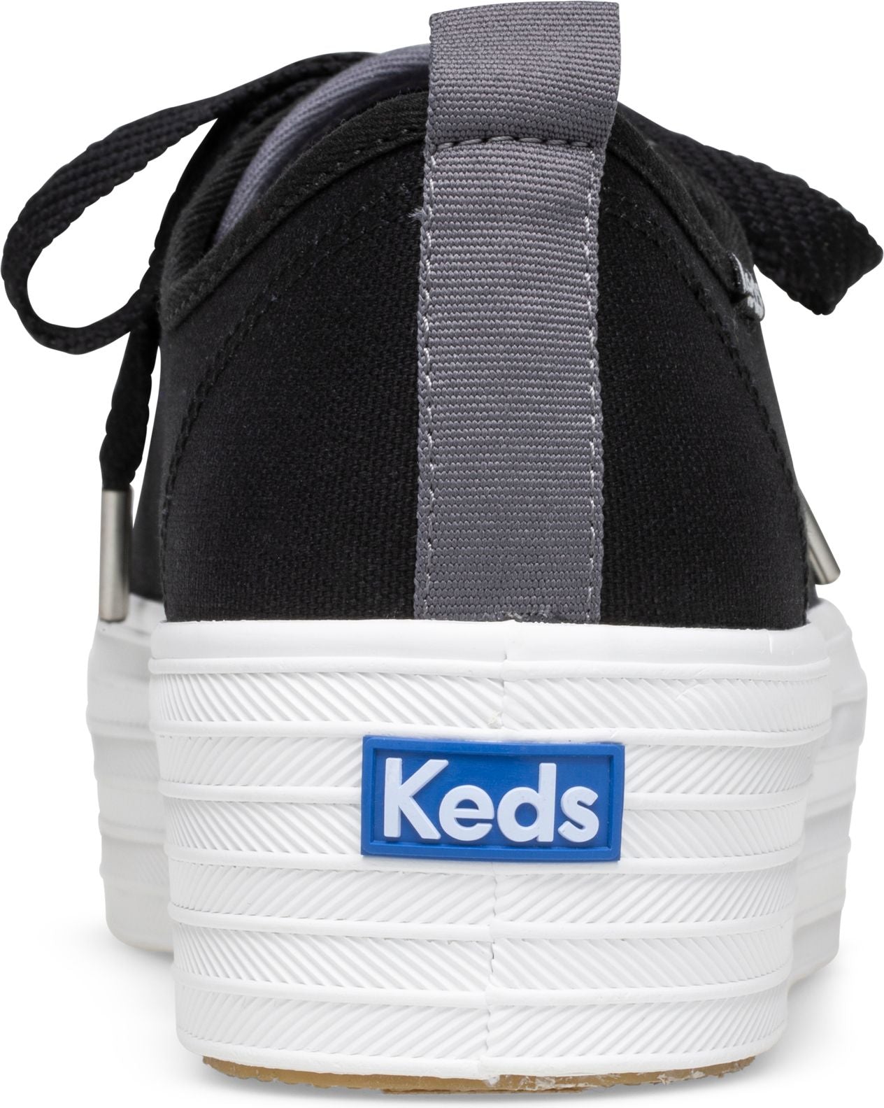 Rear view of a black platform sneaker with a thick white rubber sole and laces, featuring a blue “Keds” logo on the heel.
