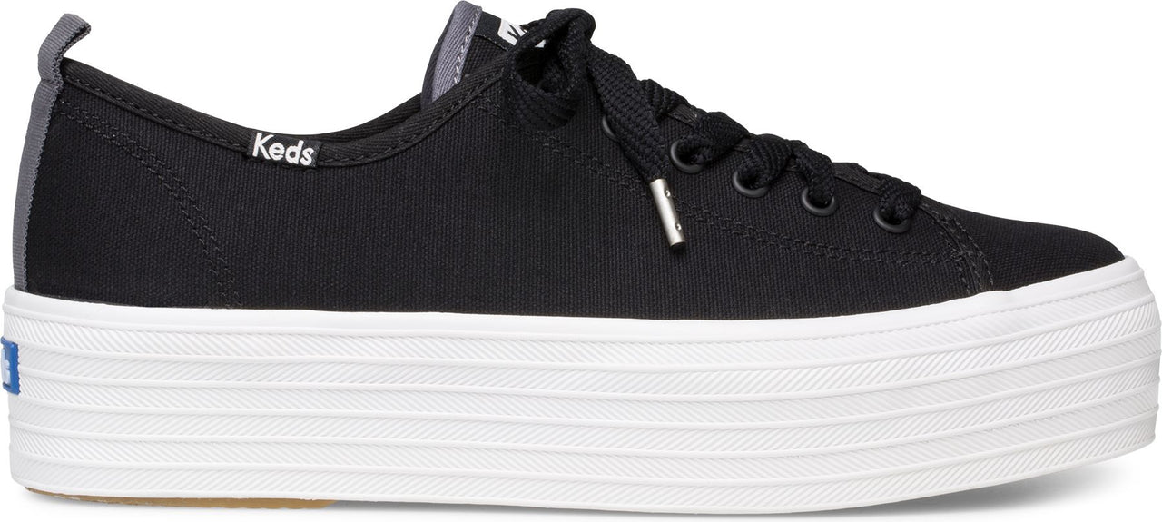 Black sneakers with laces and a white platform sole. The name "Keds" is visible on the side.