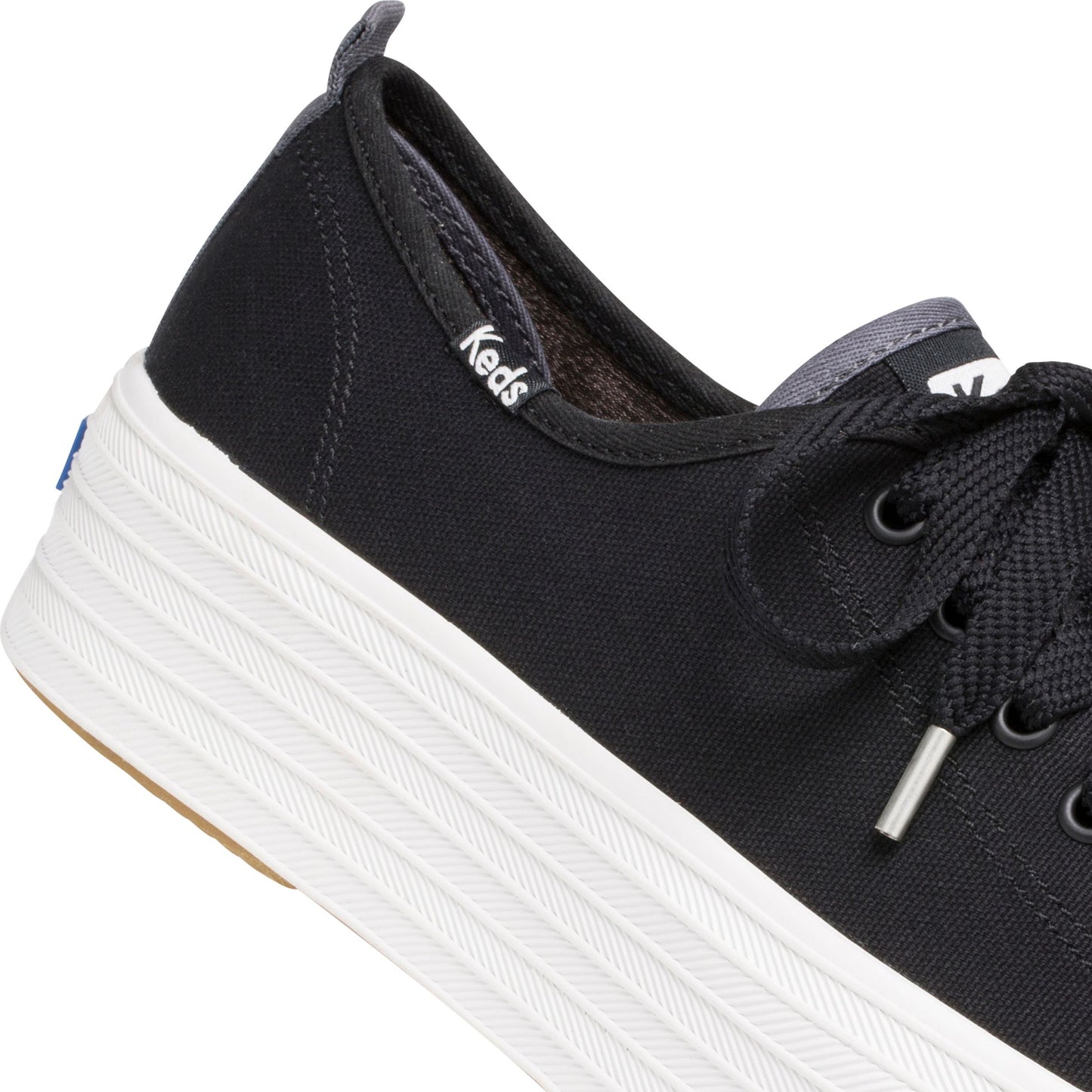 Close up of a black canvas shoe with white platform sole with Keds logo on the side.