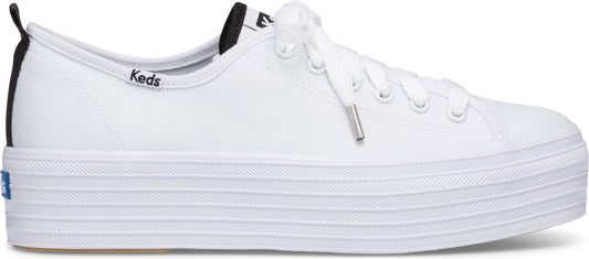 A white sneaker with white laces and a thick, ridged white sole. 'Keds' is written in small letters on the side.