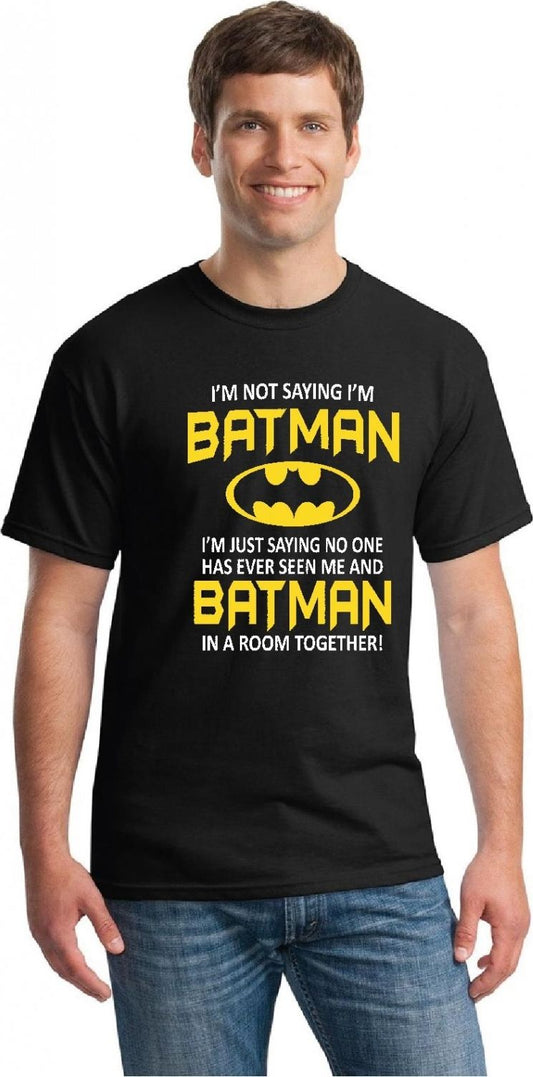 A man wearing a black t-shirt with the text "I'M NOT SAYING I'M BATMAN" in yellow letters and the batman logo is on the shirt too.