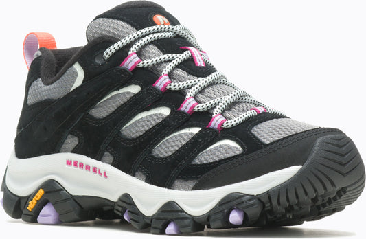 Low-cut hiking shoe with black suede overlays, gray mesh underlays, a white midsole, and black lugged outsole. The shoe features patterned laces with pink accents, a pink "MERRELL" logo on the side, and a small orange loop on the heel.
