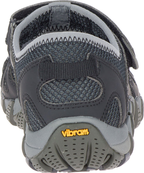 The back of a gray and black shoe with a velcro strap. The sole has 'vibram' in orange on the back.