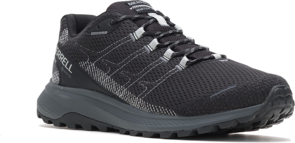 A black trail running shoe with a gray sole and reflective accents.