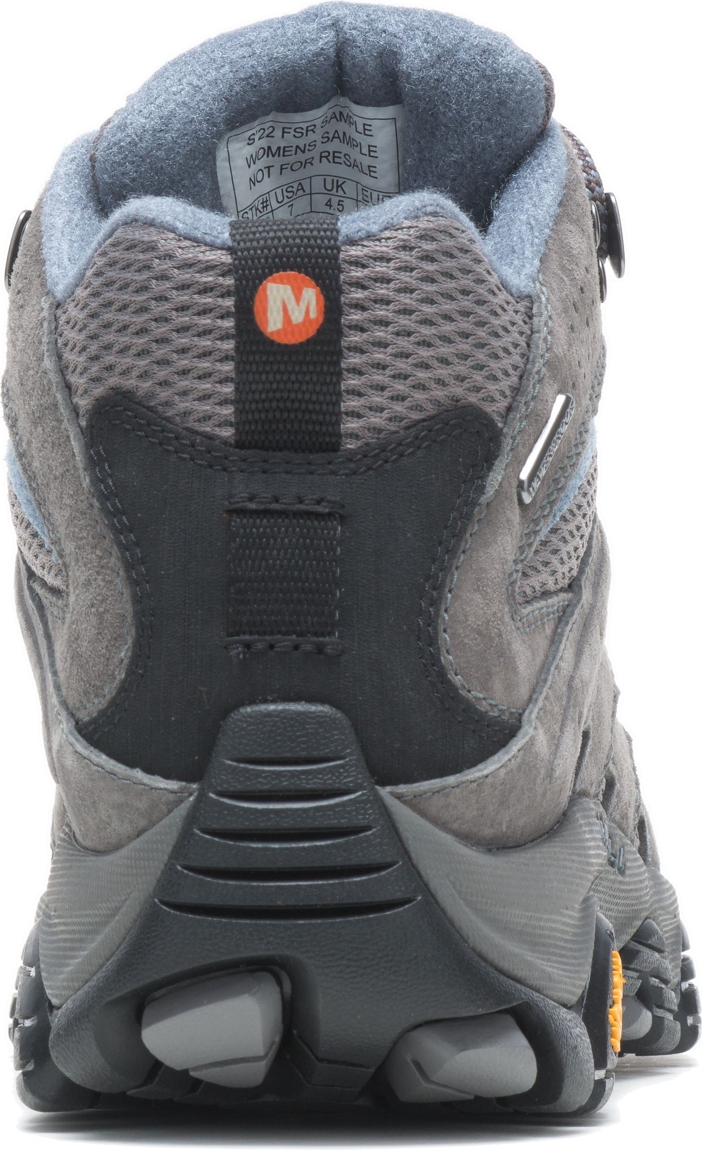 Rear view of a gray hiking boot with black accents and an orange circle with the letter 'M' on it.