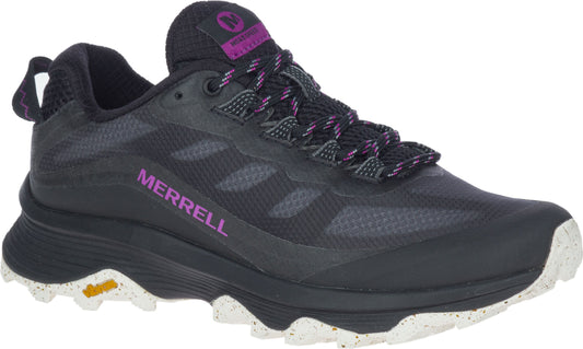 Black athletic shoe with speckled white sole and purple accents, featuring a low-profile design and hiking laces.
