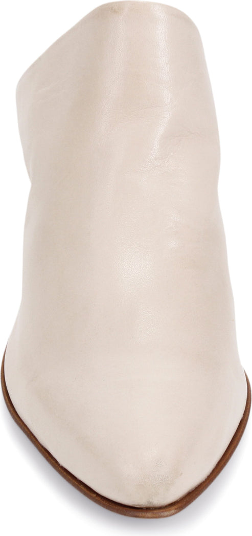 A cream-colored pointed-toe bootie.