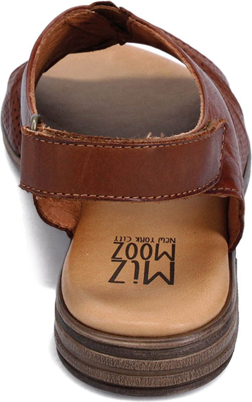 Close-up of a brown leather sandal with a back strap, showing a tan sole and the text "MIZ MOOZ NEW YORK CITY".