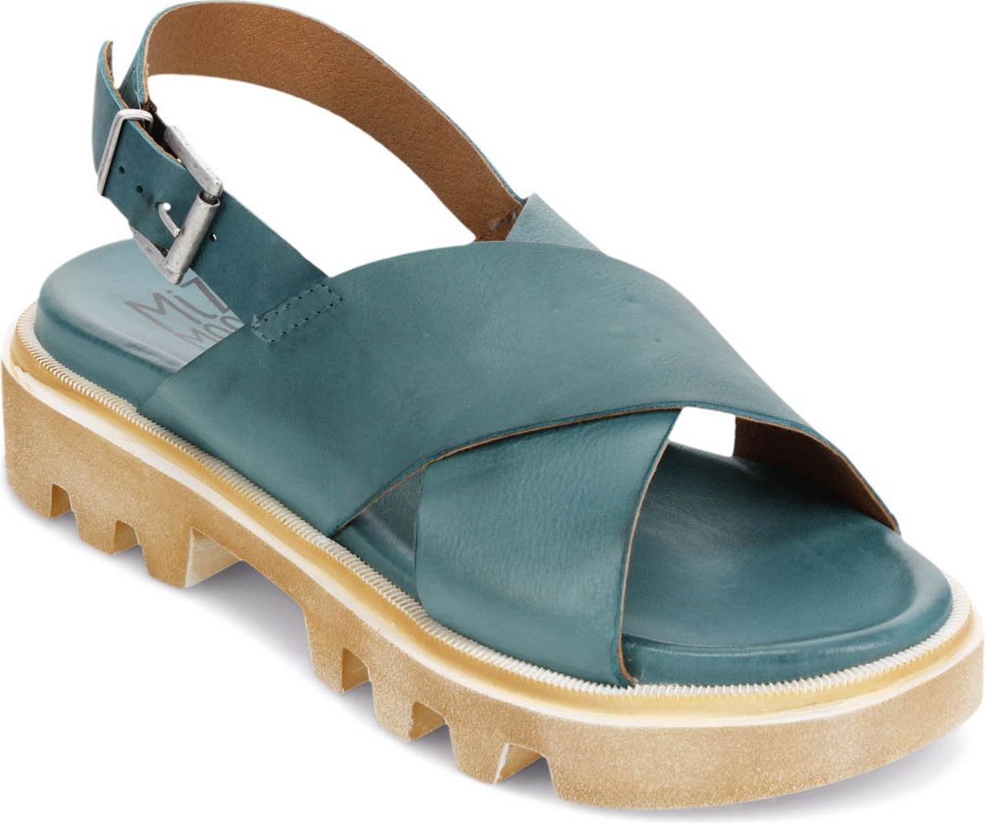 A teal sandal with cross straps and a tan lug sole, fastened with a buckle.
