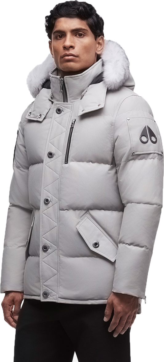 A man wearing a light gray puffy jacket with a fur-lined hood.