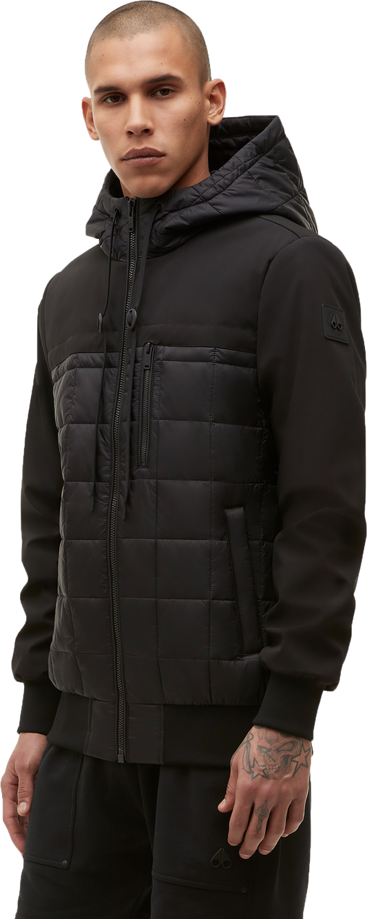 A person wearing a black hooded and quilted jacket.