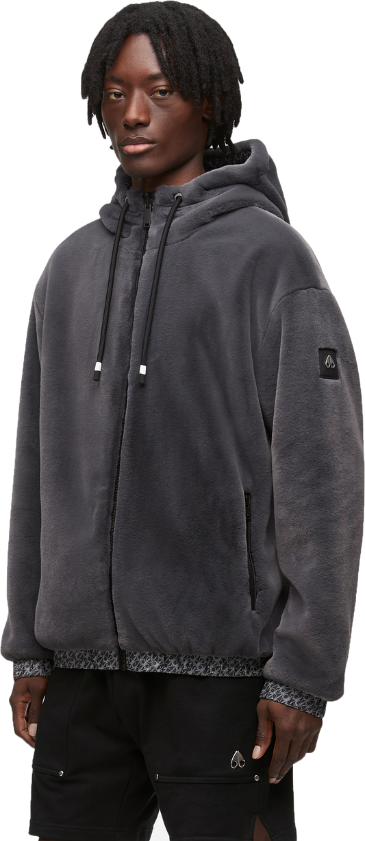 A person wearing a gray hooded fleece jacket and black shorts.