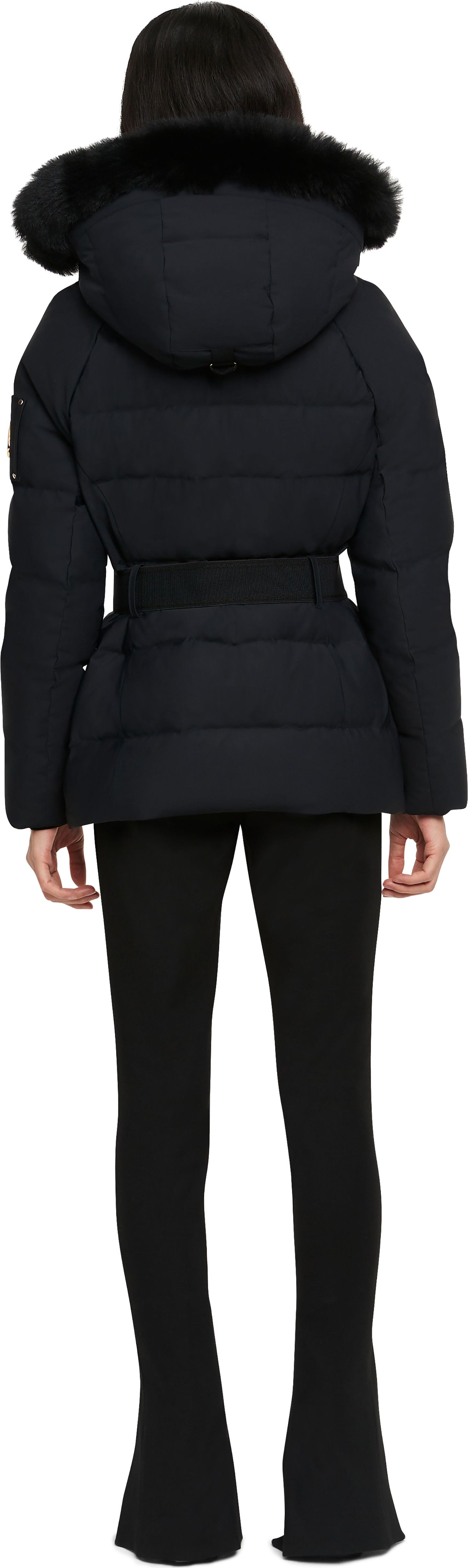 Rear view of a person wearing a black, belted, hooded puffer jacket and black pants.