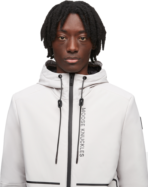 Man in light gray hooded jacket with black accents, the words 'MOOSE KNUCKLES' are visible on the front.