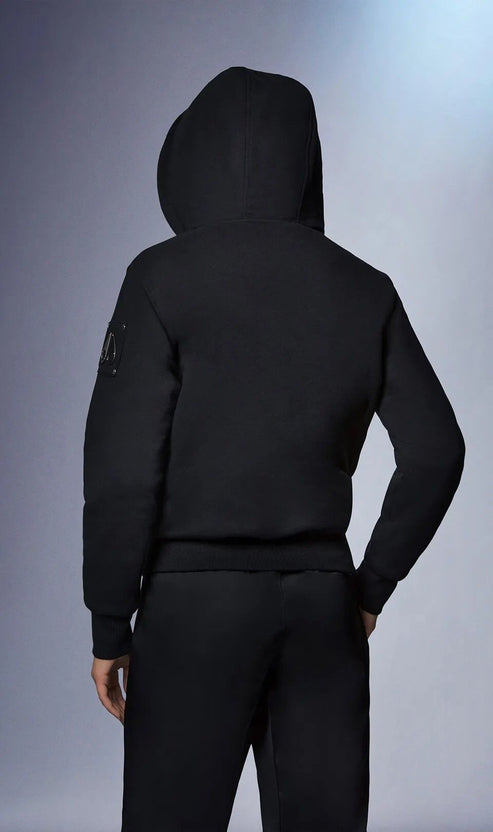 Back view of person wearing a black hooded sweatshirt and sweatpants.