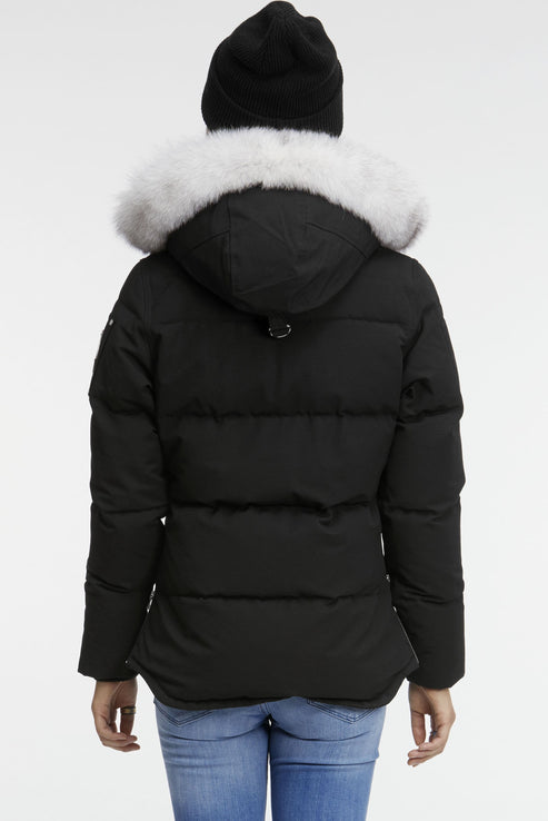 Back view of a black down puffer jacket with a white fur-trimmed hood and a person in a black knit hat.