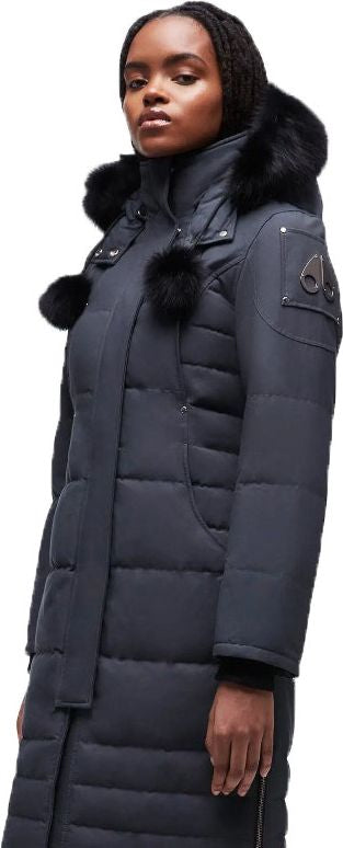 A Black woman in a long dark puffer coat with fur trim on the hood.