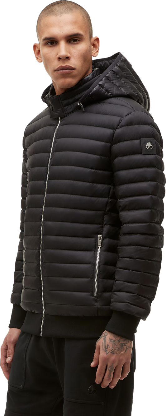 A person wearing a black, quilted, hooded jacket with a zipper closure.