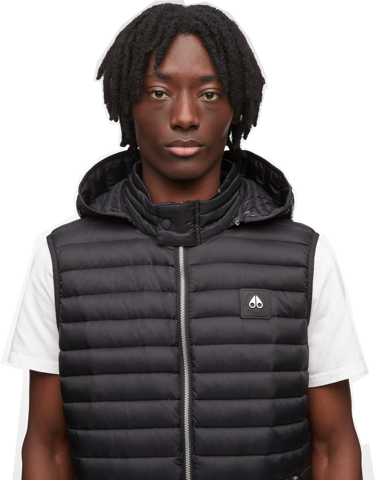 A man wearing a black puffer vest with a hood and a small logo.