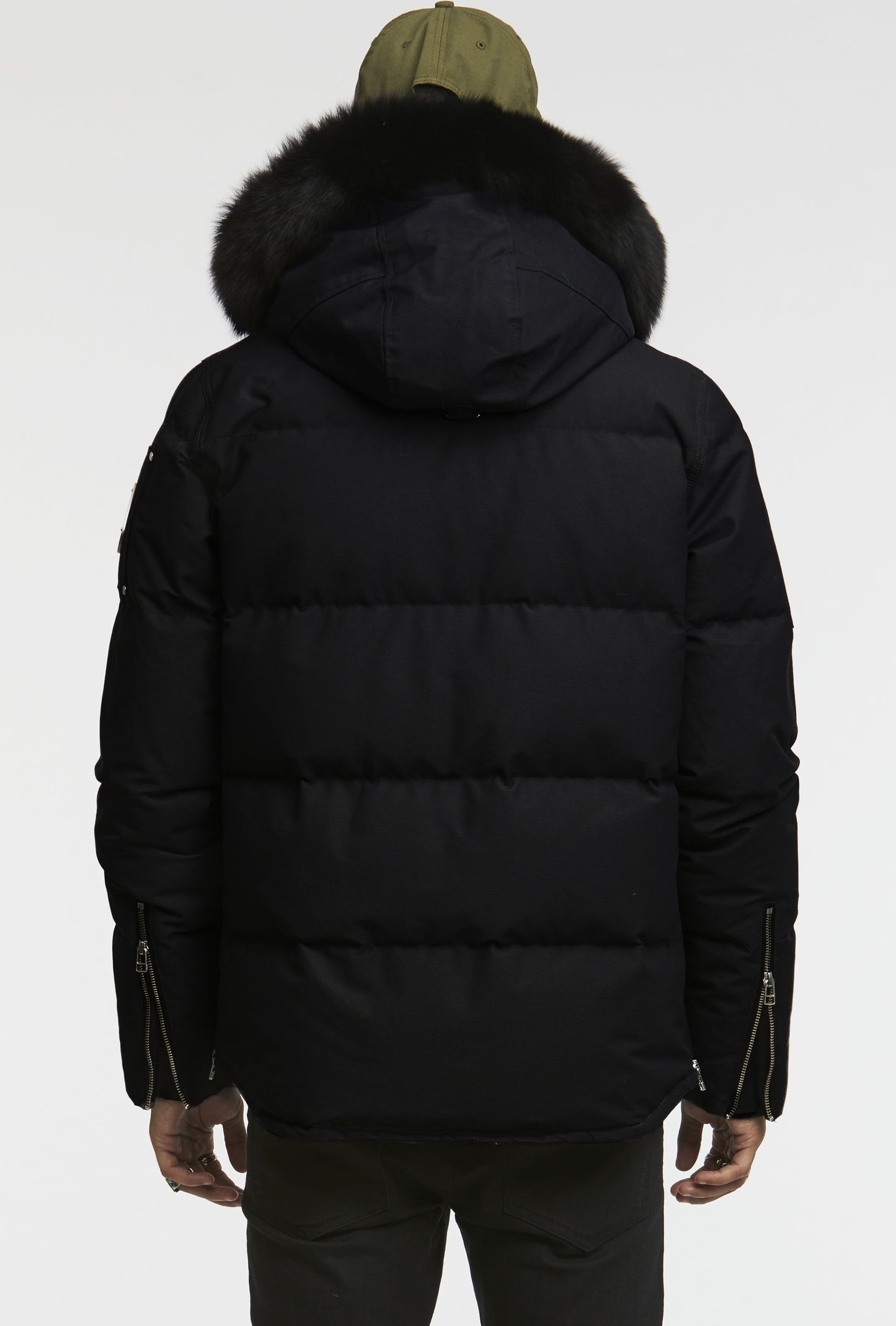 Back view of a black puffer jacket with a fur-trimmed hood and zippered cuffs.