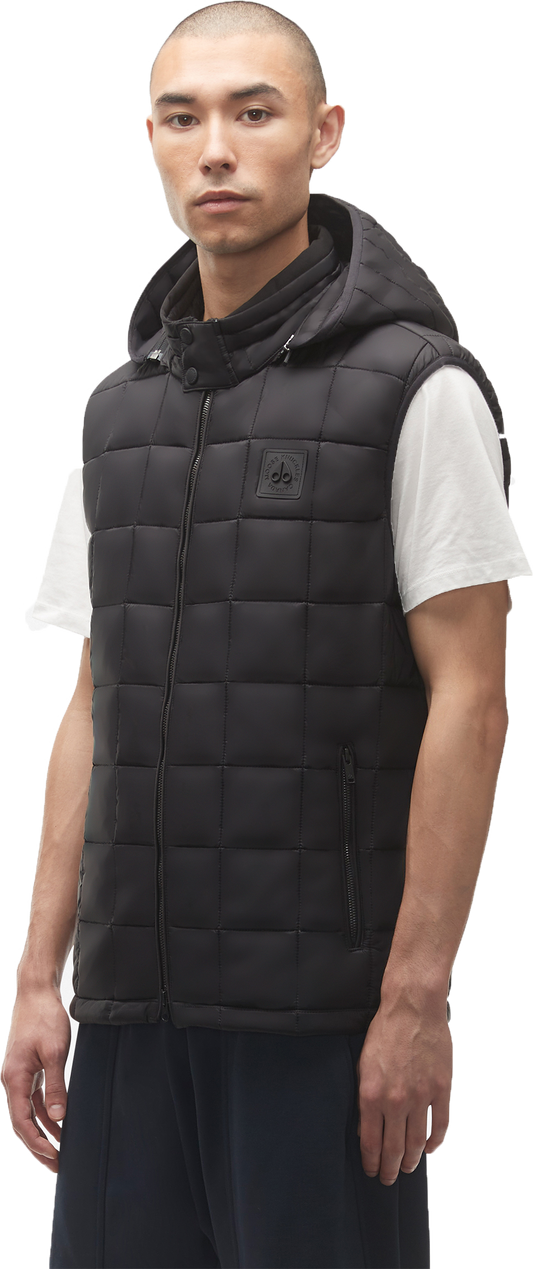 A person wears a black puffer vest with a hood.