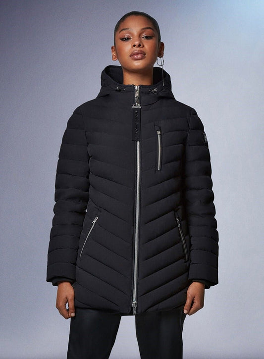 A woman wearing a black puffer jacket with diagonal stitching and a hood.