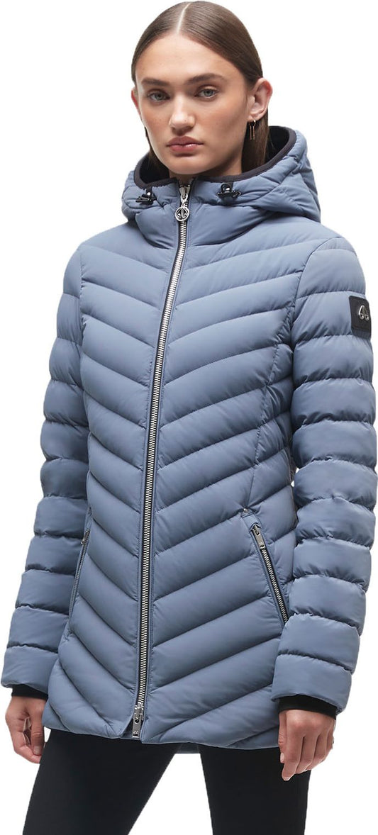 A woman wearing a blue quilted puffer jacket with a hood and a zipper.