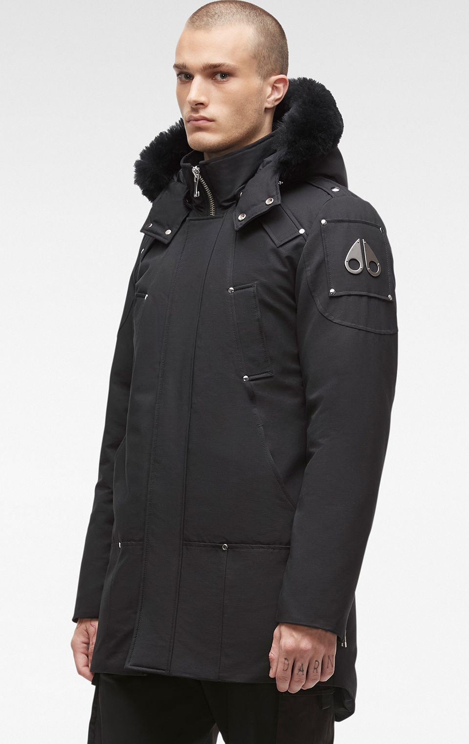 A black parka jacket with a fur-lined hood and the logo of a moose on the left sleeve.