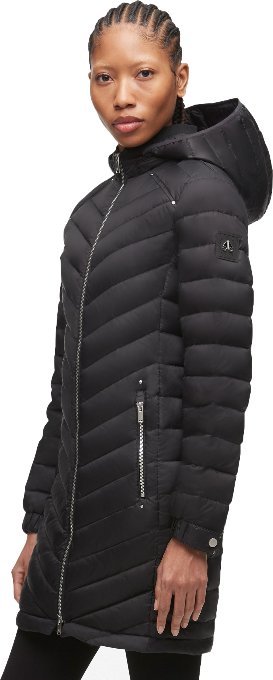 A woman wears a black quilted puffer coat with a hood.