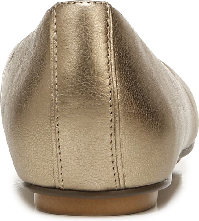 Back view of a gold-colored, flat shoe with textured material and a small, brown heel.
