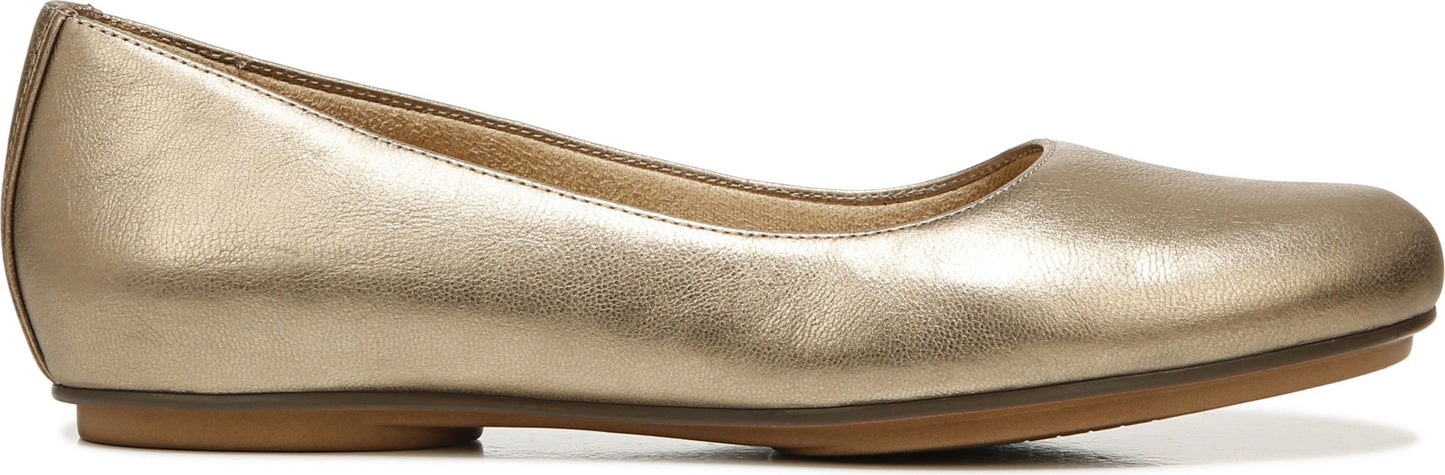 A gold-colored ballet flat shoe.
