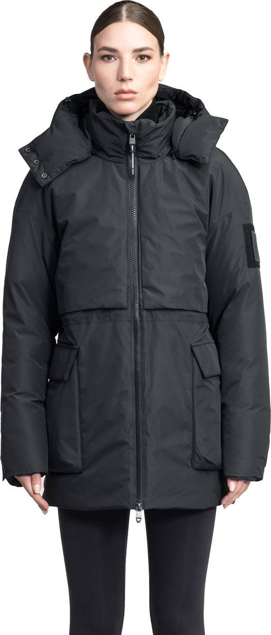 A woman wears a black, hooded, and puffy winter jacket with two pockets.